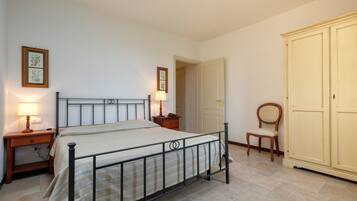 Une chambre à coucher comprenant un lit, des tables de chevet, une armoire et une chaise.