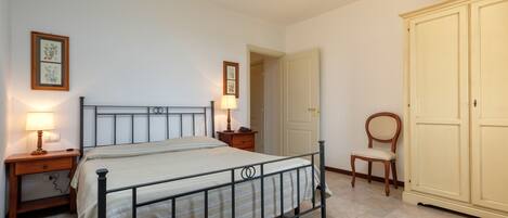 Une chambre à coucher comprenant un lit, des tables de chevet, une armoire et une chaise.