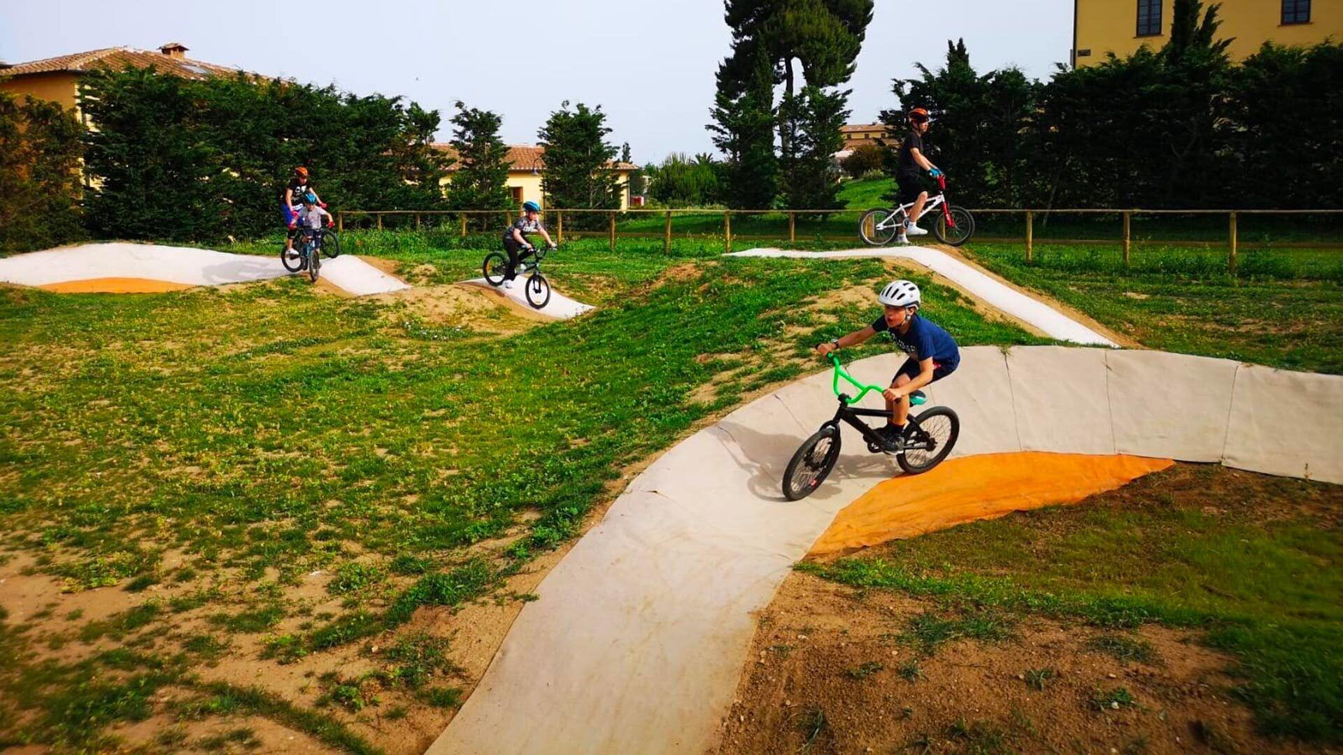Una pista BMX con ciclistas maniobrando rampas y curvas.
