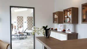Cozinha moderna com armários de madeira, bancada de mármore e um vaso com flores brancas.