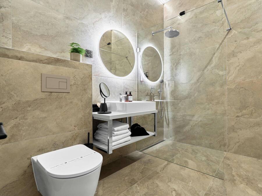 Un baño moderno con inodoro, lavamanos y ducha.