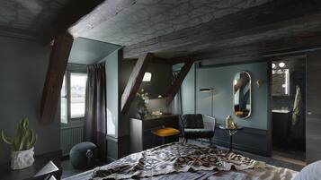 A bedroom with a large bed, a chair, a desk, a mirror, and a window with curtains.