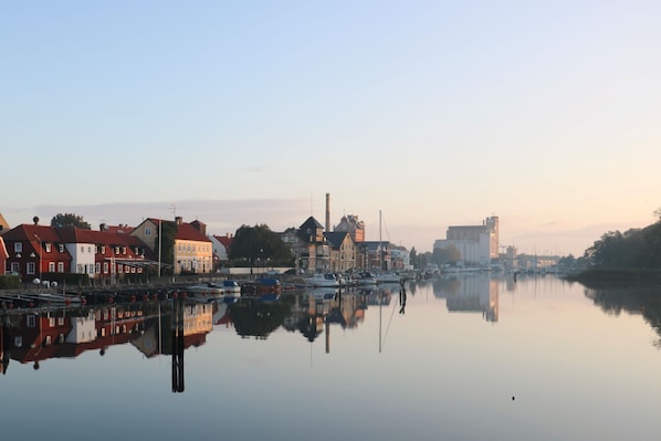 A calm waterfront with buildings reflecting on the water.