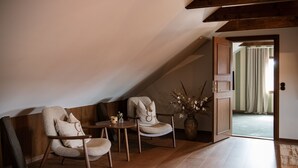 Una habitación acogedora con dos sillones, una mesita y un florero con flores secas.