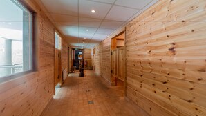 A wooden interior hallway with a tiled floor, wooden walls, and a window on the left. - Noemys Les Balcons du Viso  (Abriès-Ristolas)