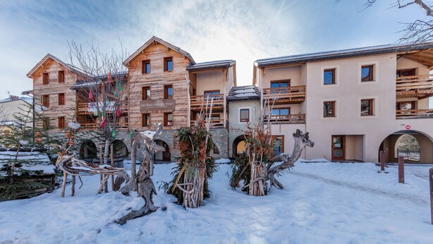 A snow-covered courtyard with wooden buildings, including a sign that reads "LE BALCON DES VISO". - Noemys Les Balcons du Viso  (Abriès-Ristolas)