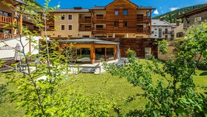 A multi-story wooden building with balconies, a covered outdoor seating area, and a well-maintained lawn. - Noemys Les Balcons du Viso  (Abriès-Ristolas)