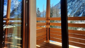 A wooden balcony with a view of snow-covered mountains. - Hotel Aigle (Courmayeur)