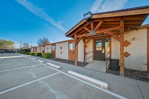 A building with a wooden facade, a covered entrance, and a parking lot. - Travelodge by Wyndham Kanab (Kanab)