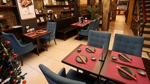 A restaurant with booths and tables, wooden decor, and a Christmas tree. - Cumbali Luxury Boutique Hotel (Istanbul)