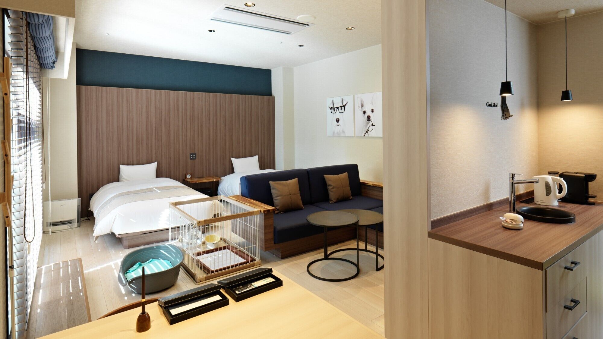 Una habitación de hotel con cama, sofá, mesita y kitchenette.