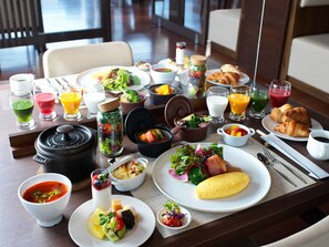 Un bufé de desayuno con diversos platos, bebidas y una taza de café.