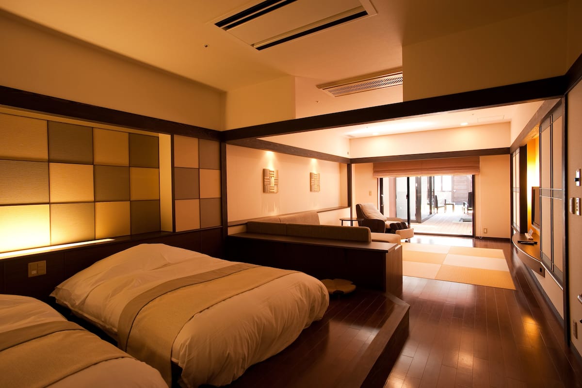 Habitación de hotel con una cama grande, un sofá y vistas al exterior.