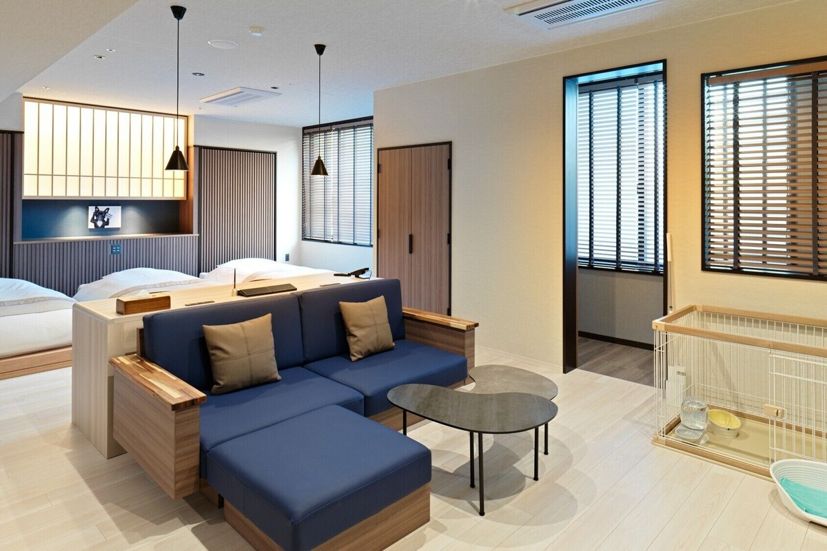 Una habitación de hotel moderna con cama, sofá, mesita y cuna.