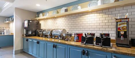 A self-serve breakfast station with various food options and a coffee machine.
