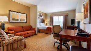 A hotel room with a bed, a sofa, a desk, and a chair. - Country Inn & Suites by Radisson, Texarkana, TX (Texarkana)