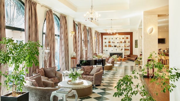 A spacious living room with a grand piano, comfortable seating, and a fireplace.