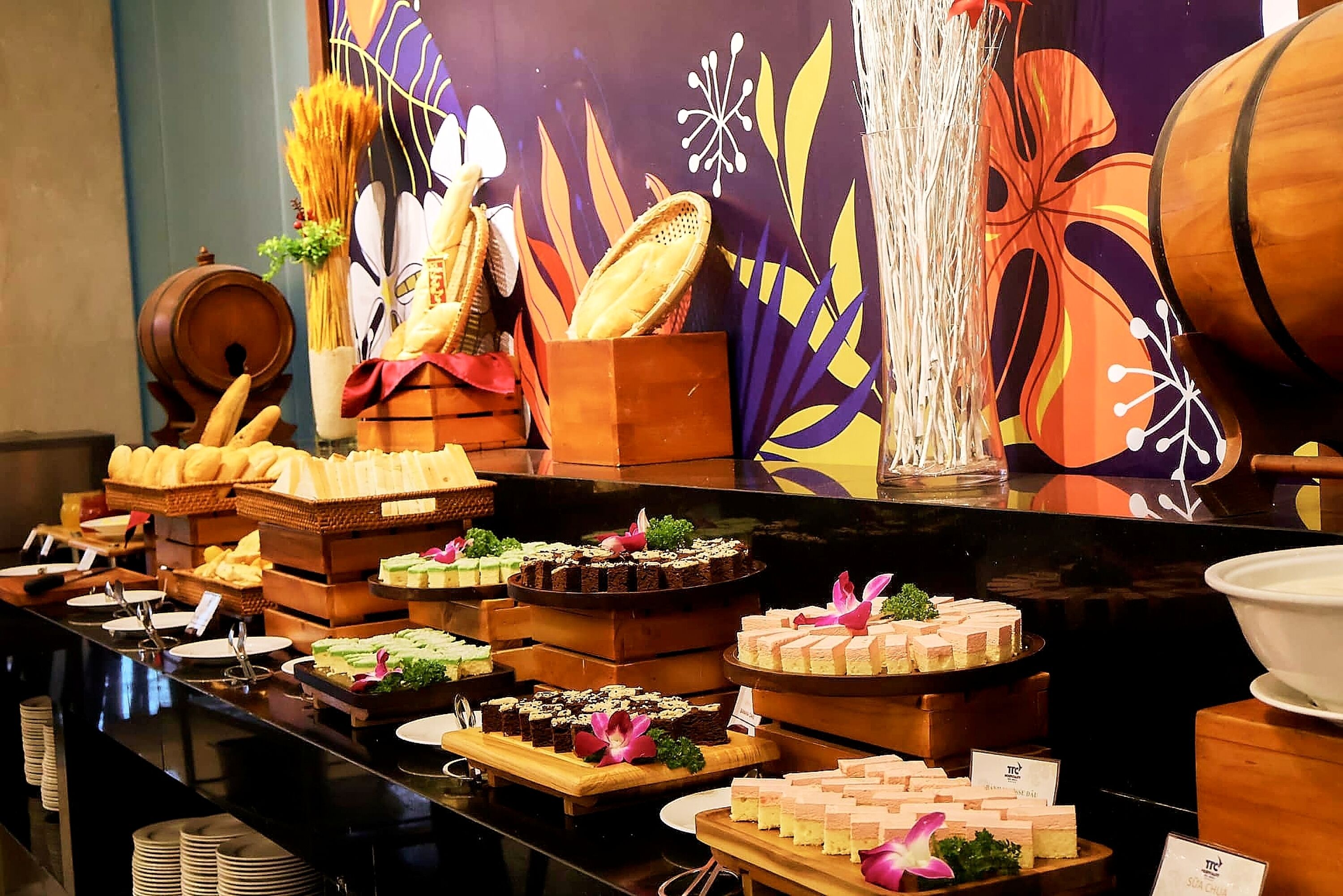 A buffet with various food items and a decorative backdrop.