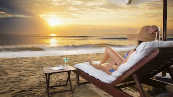 En la playa, playa de arena blanca, camastros y sombrillas