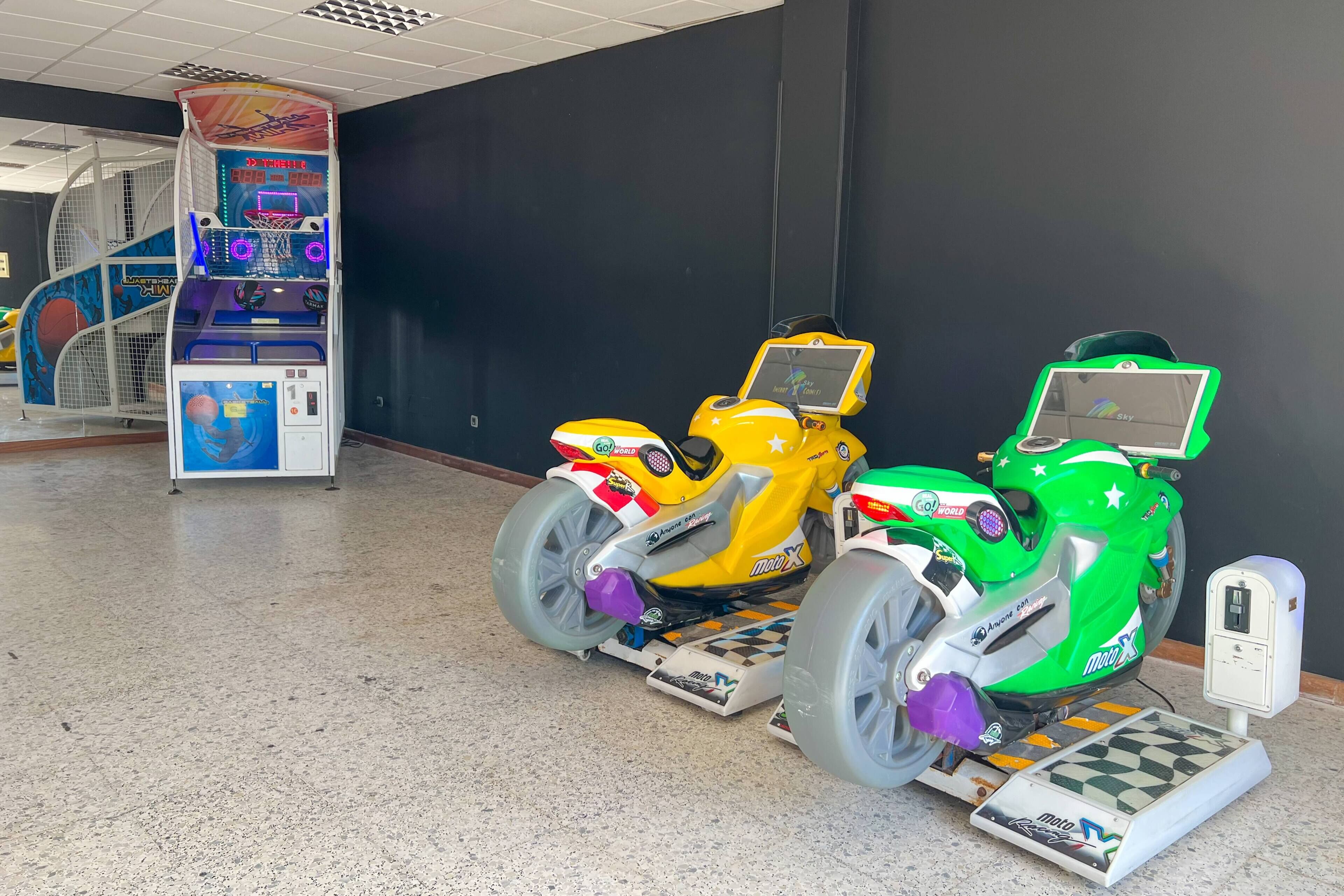 Una sala de videojuegos con simuladores de carreras.