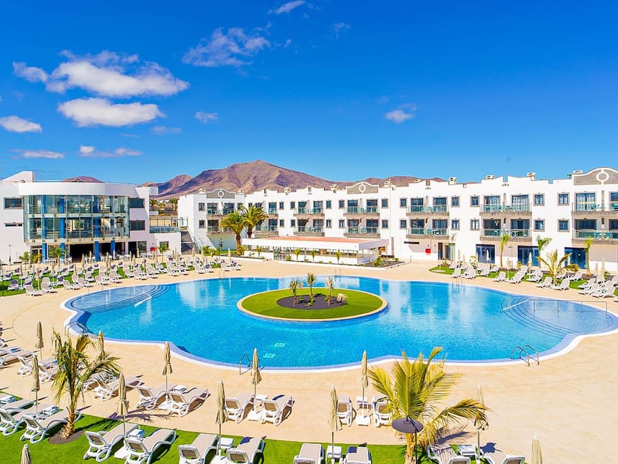 Alberca al aire libre, sombrillas en la alberca y camastros