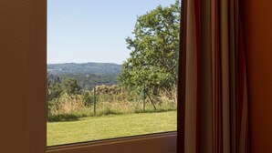 A window with a view of a grassy field, trees, and hills in the distance. - The Originals Access, Hôtel Tulle (Tulle)