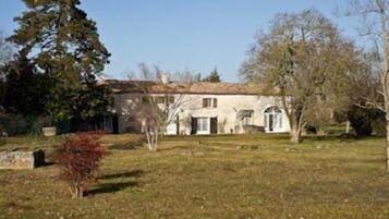 Una casa de un piso con fachada simétrica, una entrada central y un pequeño jardín delantero.