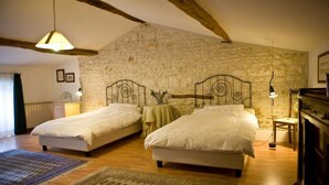 A bedroom with two single beds, a stone wall, wooden beams, and a rustic aesthetic. - La Bribaudonnière (Saint-Palais-de-Phiolin)