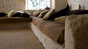 A cozy room with a stone wall, a window with a view, and a bed with pillows. - La Bribaudonnière (Saint-Palais-de-Phiolin)