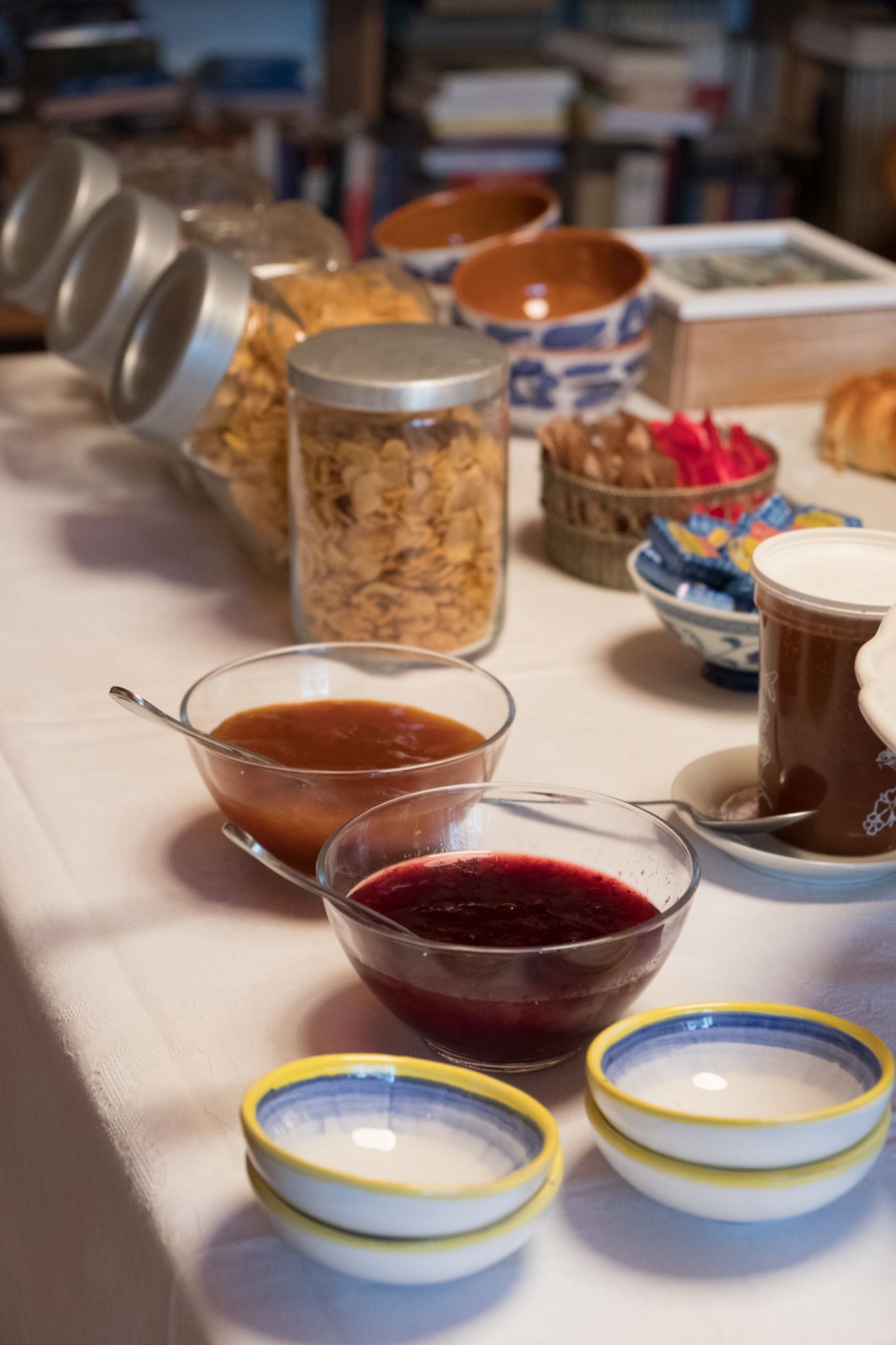 A table with various food items and containers, including jars, bowls, and plates.