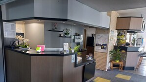 A modern reception area with a wooden counter, a small plant, and a map on the wall.