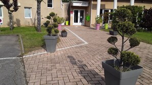 A paved walkway leading to a building with a sign reading "Hotel Alys".