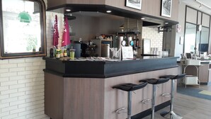 A bar area with a counter, stools, and various bottles and glasses.