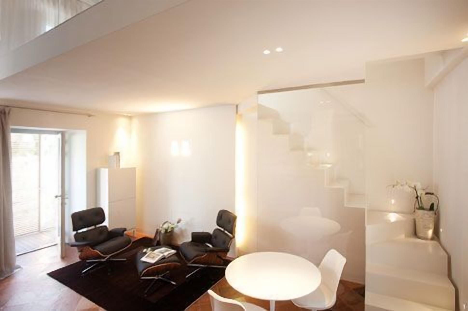Una sala de estar moderna con un conjunto de sofá, una mesa de centro y una escalera.