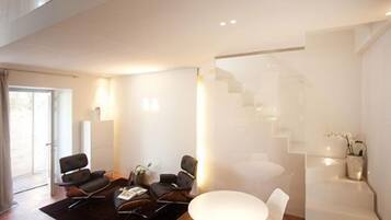 Una sala de estar moderna con un conjunto de sofá, una mesa de centro y una escalera.