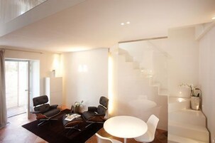 Una sala de estar moderna con un conjunto de sofá, una mesa de centro y una escalera.