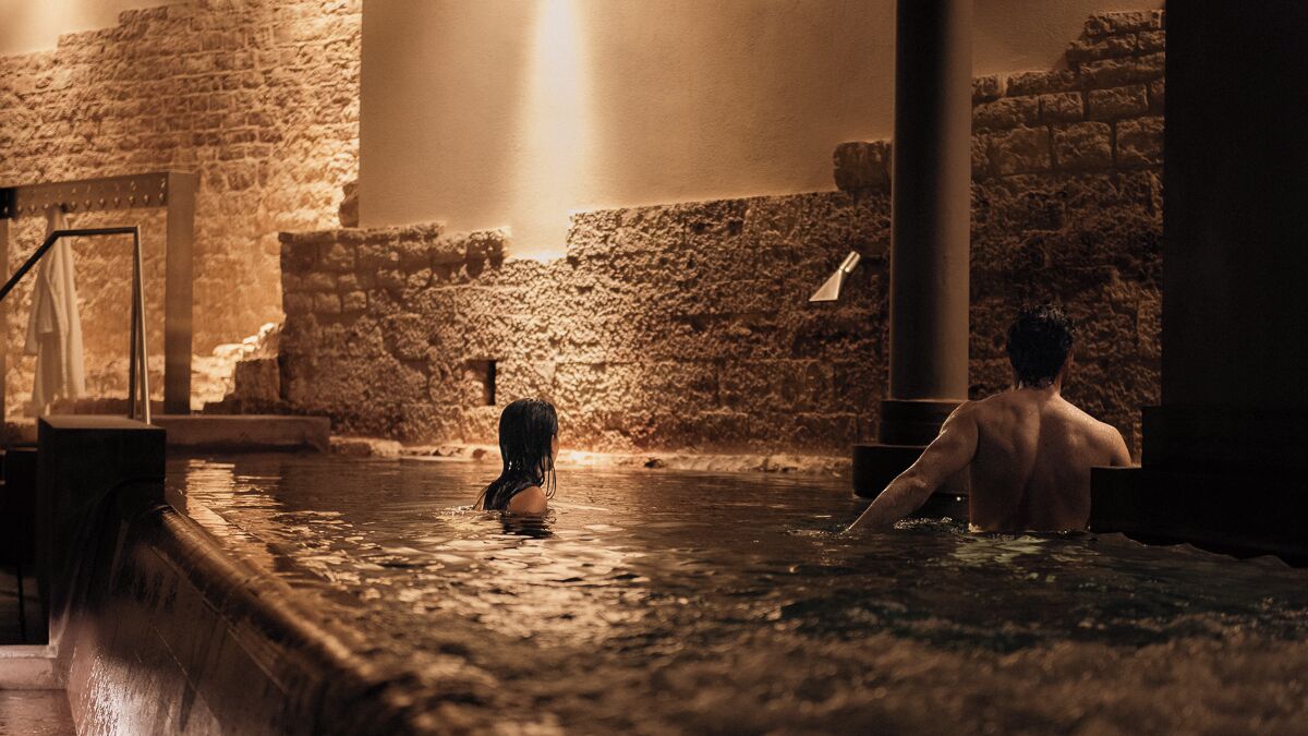 A historical site with stone walls and a pool.
