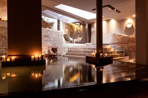 A modern spa area with a reflective pool, stone steps, and candles. - Nun Assisi Relais Spa Museum (Assisi)