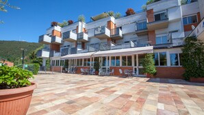 A multi-story hotel with outdoor seating and a tiled patio. - Ostello di Bergamo (Bergamo)