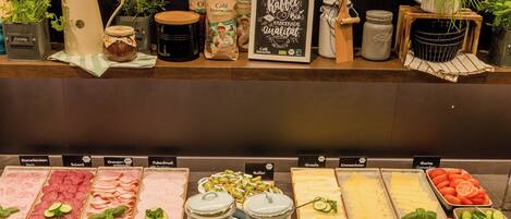 A food display with various meats, cheeses, and vegetables.