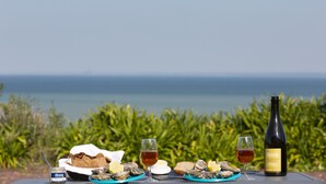 A table with food and wine, overlooking the sea. - Les Chambres de la Métairie du Vauhariot (Cancale)