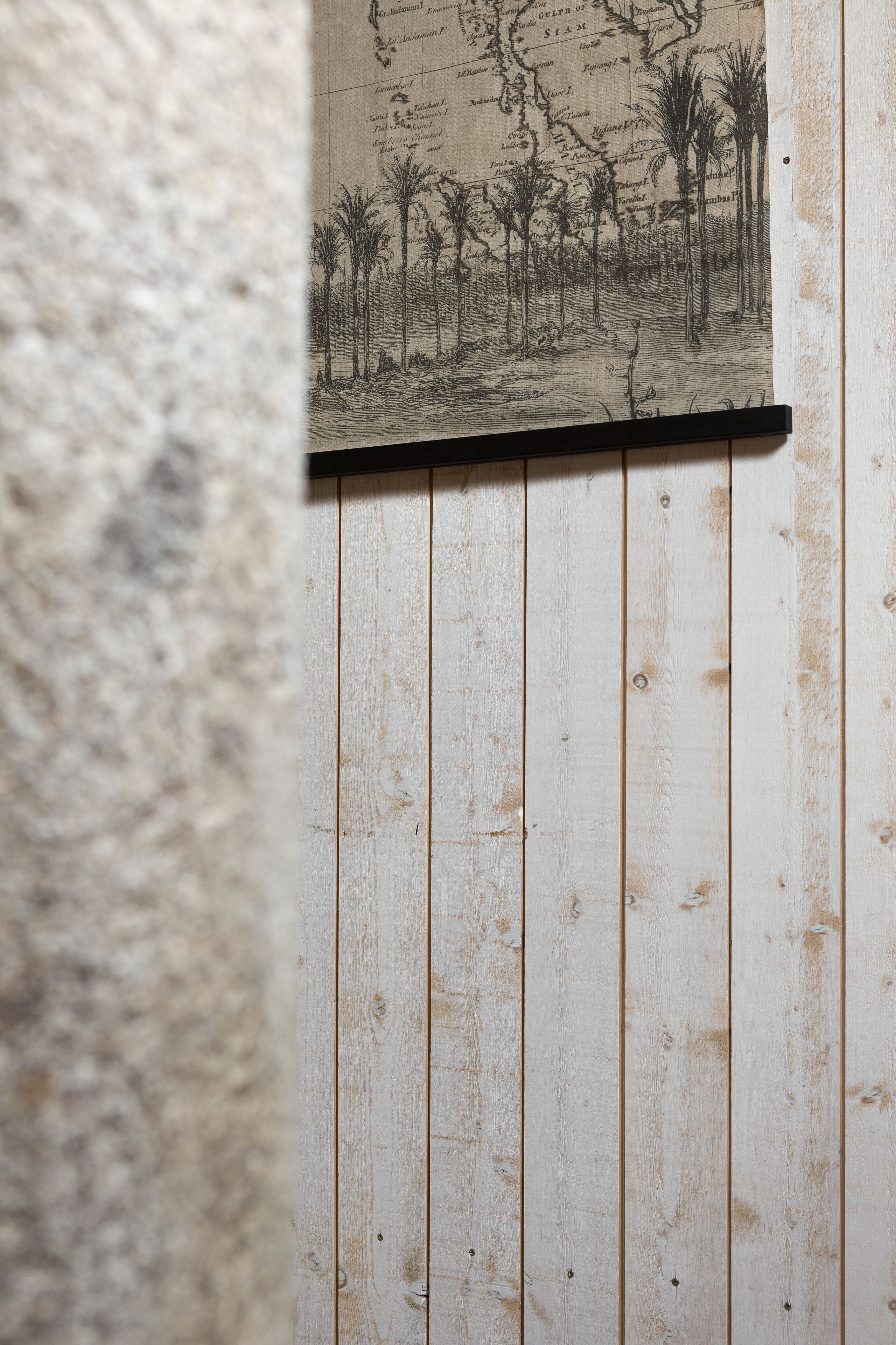 A wooden wall with a framed map and a wooden panel.