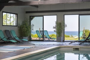 Una piscina techada, sillones reclinables de piscina