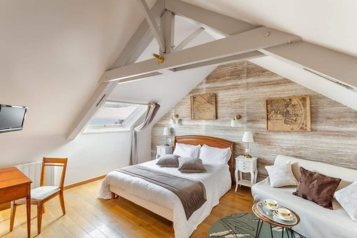 Ein Schlafzimmer mit Bett, Nachttischen, einem Schreibtisch und einem Fenster.