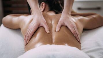 Une personne reçoit un massage du dos sur un lit.