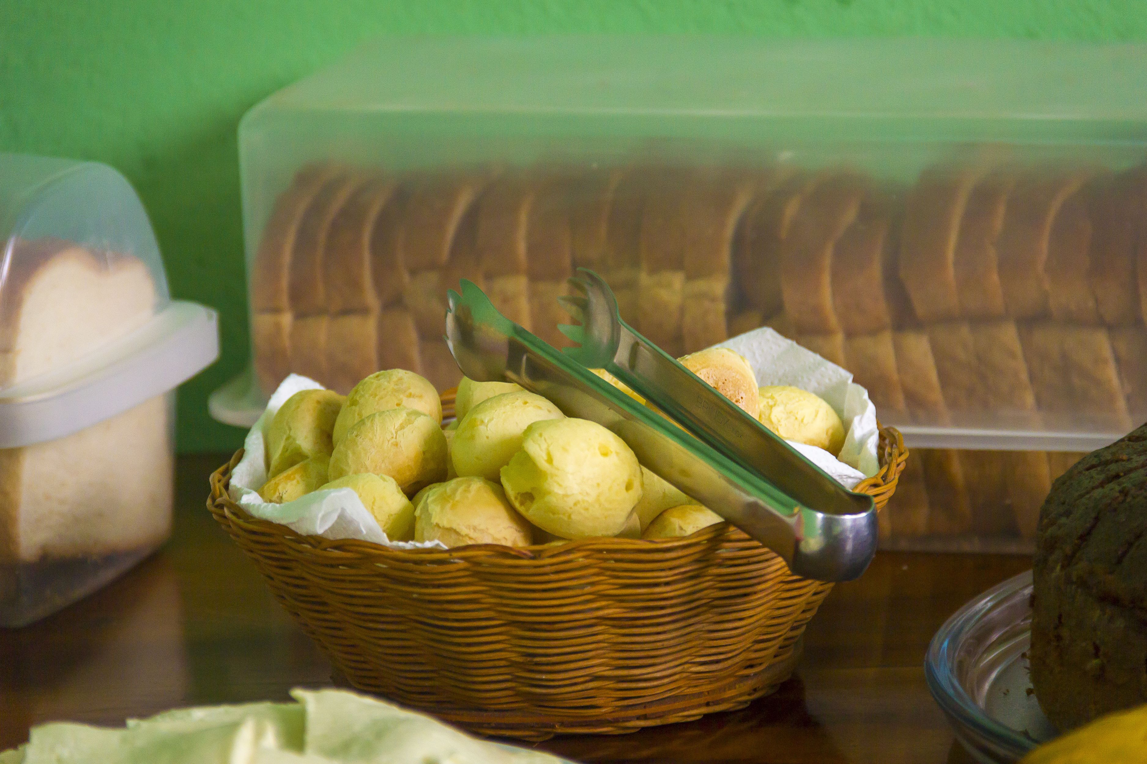 Una cesta con panes y una hogaza sobre una mesa.
