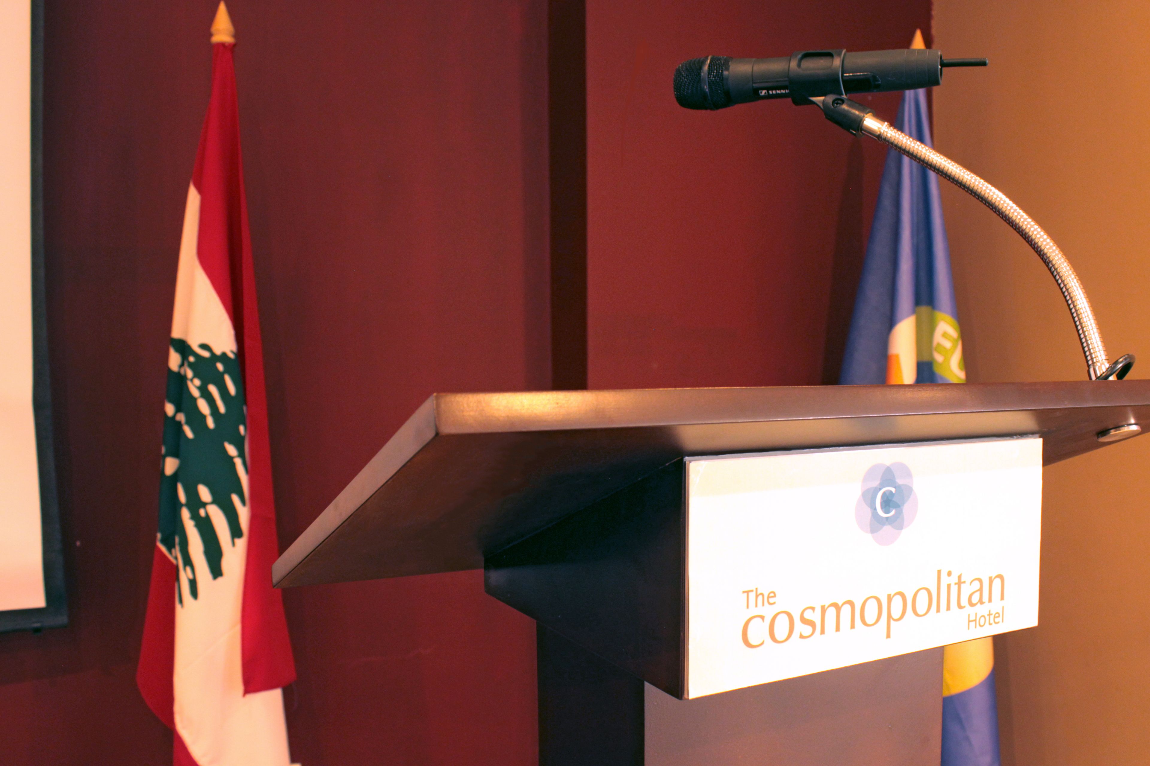 A podium with a microphone and a sign that reads "The Cosmopolitan Hotel."