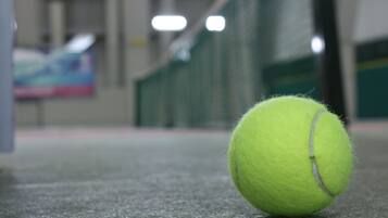Une balle de tennis sur une surface verte.