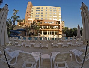 A hotel with a pool area, lounge chairs, and a water slide. - The Cosmopolitan Hotel (Dekwaneh)