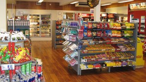 Un supermercado con estantes llenos de aperitivos, bebidas y productos envasados.
